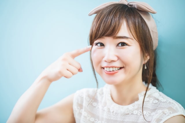 眉毛を指す女性