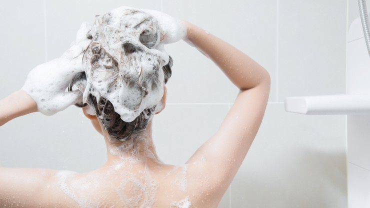 シャンプーで髪を洗う女性の画像