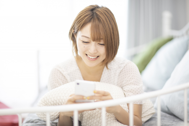 スマホを見て喜ぶ女性