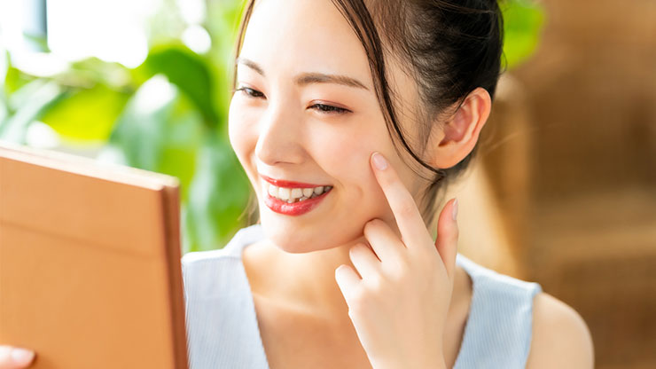 笑顔で鏡を見る女性