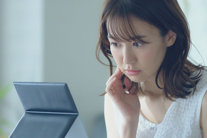 鏡を見つめる女性
