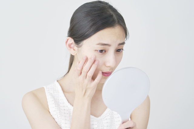 鏡を覗き込む女性