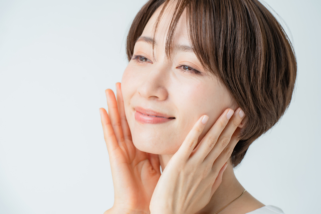 フェイスラインに手を添える女性